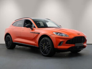 Front three-quarter view of an orange Aston Martin DBX